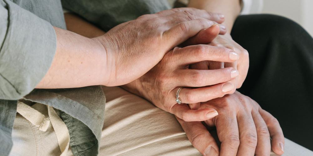 man en vrouw hebben hun beiden handen op elkaar liggen